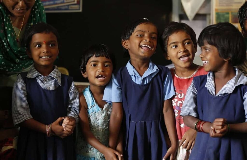 5 young school girls smiling and looking at each other